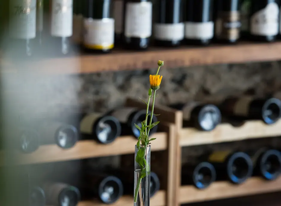 Blume vor einem Weinregal im Hotel Burgblickhotel in Bernkastel-Kues, Mosel